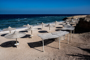 view of a deserted beach on a sunny day with sea and blue sky