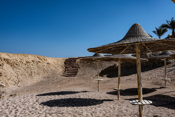 view of a deserted beach on a sunny day with sea and blue sky