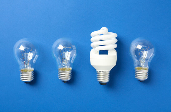 Vintage And Modern Lightbulbs On Blue Background, Flat Lay