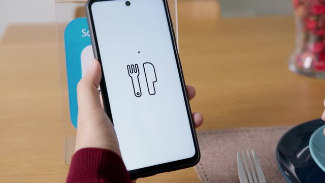 Hand's customer scan QR code for online menu service at table in restaurant during pandemic coronavirus. New normal contactless technology lifestyle protection coronavirus pandemic in restaurant