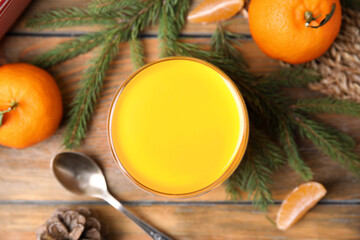 Obraz na płótnie Canvas Delicious tangerine jelly and fir branches on wooden table, flat lay