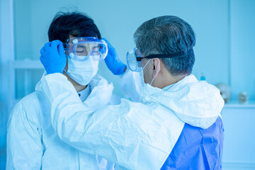 Asian medical scientists wearing PPE protective suit work n laboratory for virus pandemic vaccine