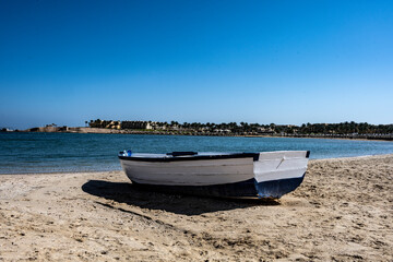 Obraz premium deserted beach with wicker umbrellas and lack of vacationers against the blue sky