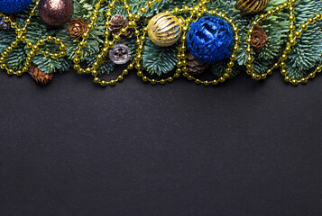 Black New Year background. Fir branches with New Year's toys and cones.