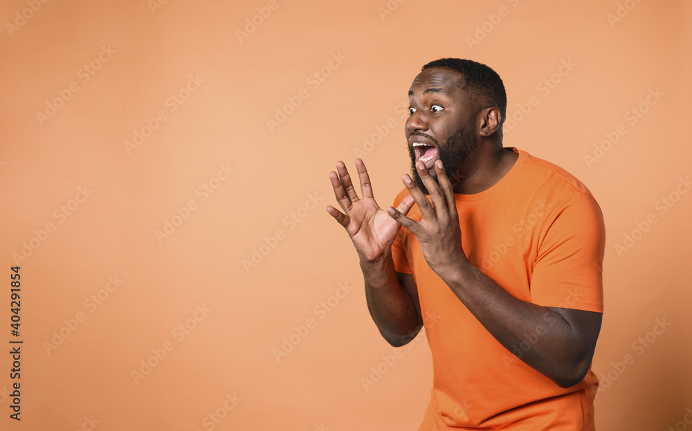 Wall mural amazed and shocked expression of a boy over orange background