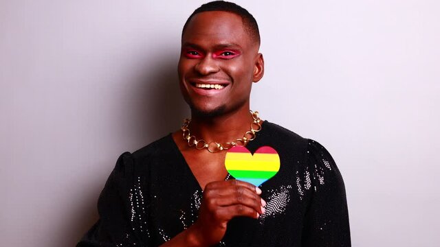 crossdress mixed race drag queen in glister dress feeling pride and confidence in make up in studio white background