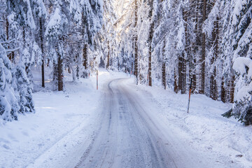 Winterly and snowy mountain road in a forest