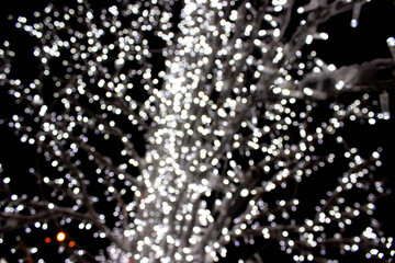 Defocused white  bokeh lights for background - holidays, decoration and party concept. Silver and white bokeh lights . Abstract wallpaper. Bokeh lights on black background, on dark, blurred texture.