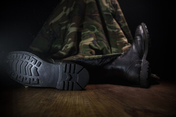 War concept. Old military shoe in a dark toned foggy background. Creative concept of conflict between countries, military aggression.