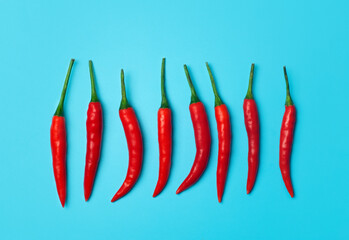 Chili peppers on a colored blue background. Red hot chili peppers as an ingredient of Asian and...