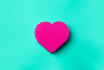 Valentine's day  background. Red heart on a green minimal background. Love, romance and heart concept.