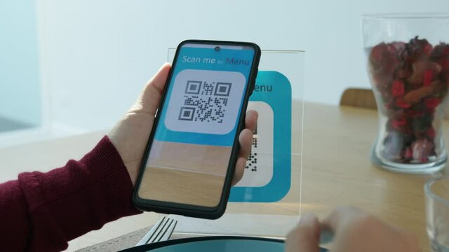 Hand's customer scan QR code for online menu service at table in restaurant during pandemic coronavirus. New normal contactless technology lifestyle protection coronavirus pandemic in restaurant