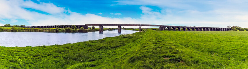 Fototapeta na wymiar A panorama view from the River Trent levy of the abandoned railway viaduct at Fledborough, Nottinghamshire in springtime