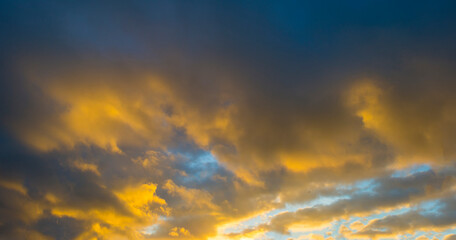 Yellow white clouds in a blue sky in bright sunlight at sunrise in winter, Almere, Flevoland, The Netherlands, January 10, 2021