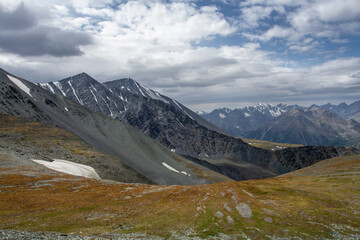 Rocky pass Karatyurek with sparse vegetation in the Altai Mountains. Mountain peaks in a blue haze.