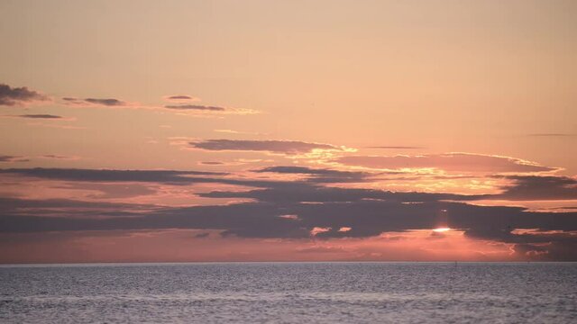 Time lapse. Sunrise over the sea in the sky clouds and flying birds