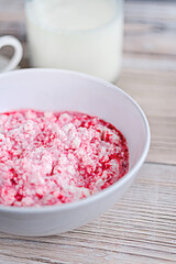 Cottage cheese with sour cream and raspberry jam in a white bowlon a white wooden table. Healthy breakfast. Rustic style.