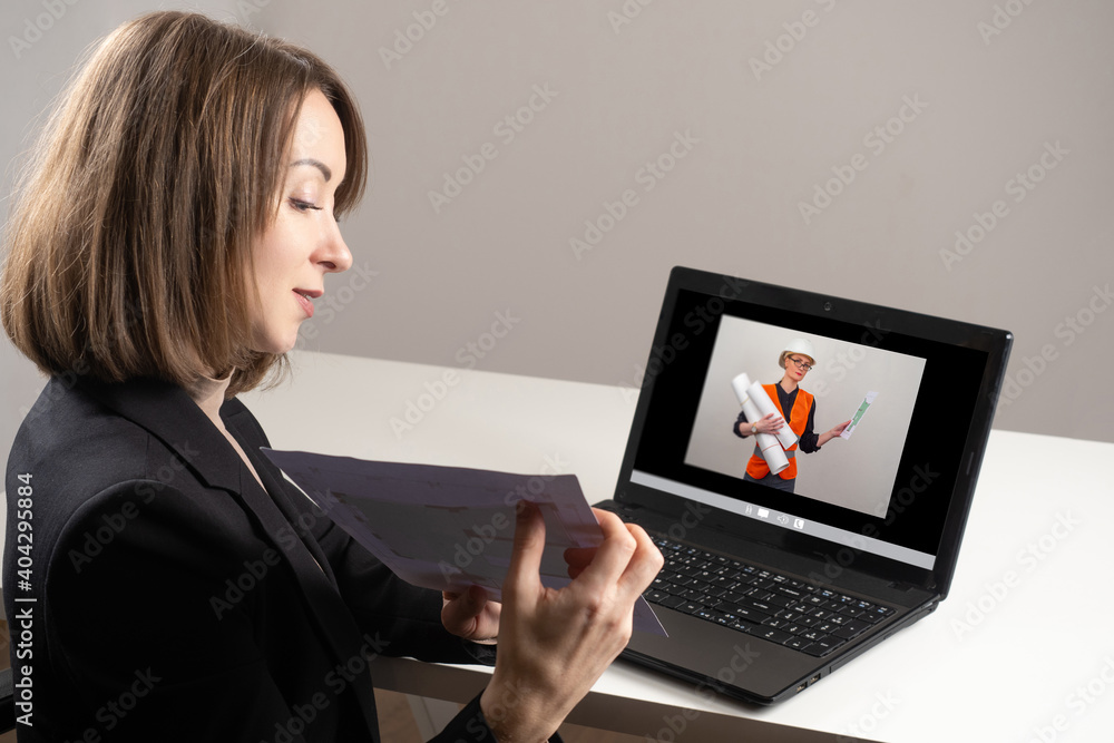 Poster communication between architect and builder via video link. woman architect in front of laptop. she 