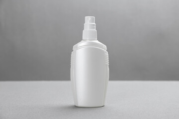 Bottle with insect repellent spray on grey background
