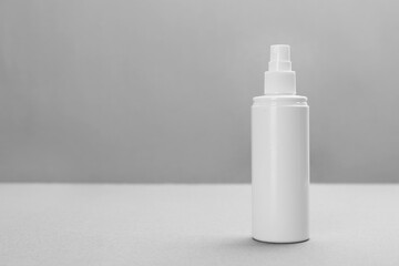 Bottle with insect repellent spray on grey background, space for text