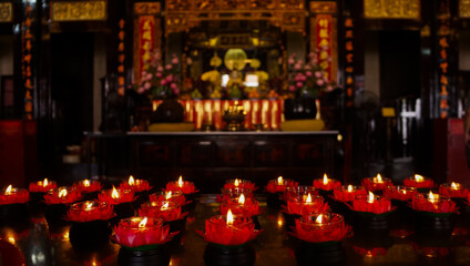 Fototapeta na wymiar Lighted candles in the Buddhist temple