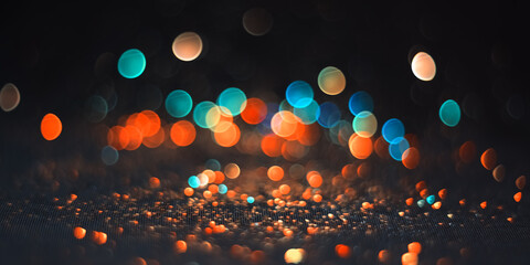 Background abstract glitter lights blue and orange on black defocus. Beautiful banner colored bokeh.