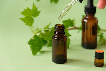 Essential oil falling from a glass dropper on the background of other medications