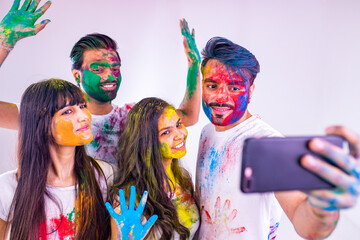 happy teenager friends with colour face and hair taking selfie photos on camera feeling good emotions together in white studio