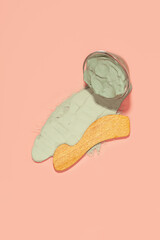 Blue cosmetic clay - face and body skin care on pink background. Top view. Flat lay