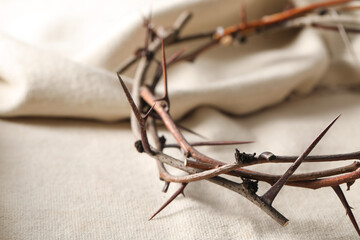 Fototapeta na wymiar Crown of thorns on white fabric, closeup. Easter attribute