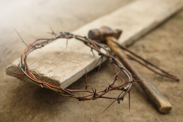 Fototapeta na wymiar Crown of thorns, hammer and wooden plank on ground. Easter attributes