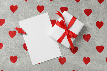 Blank card, gift box and red hearts on grey background, flat lay with space for text. Valentine's Day celebration