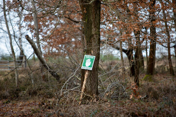 German sign for do not enter the quite zone, leaning against a tree in a heather, autum