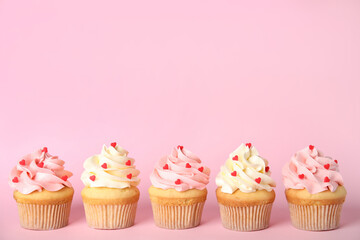 Row of tasty cupcakes on pink background, space for text. Valentine's Day celebration