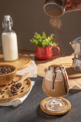 iced mocha coffee served with whipped cream topping and chocolate syrup in wine glass place on wooden table