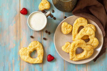 Breakfast for valentine's day or mother's day concept. Curd cheese pastries and a cup of cappuccino coffee on a rustic table. Top view flat lay.