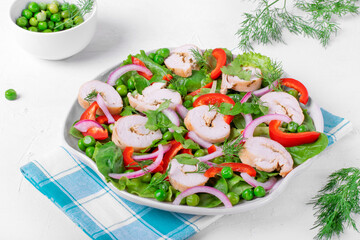 Salad with turkey rolls, green peas, bell pepper, Spanish onion, spinach and lettuce on the big serving dish