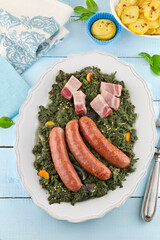 Braised cabbage with smoked sausage on light blue wooden background