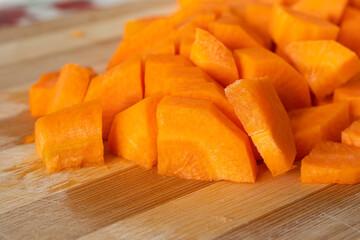 A pile of fresh carrots cut on wooded board