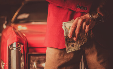 Men with Pile of Cash Money in Front of His Classic Car