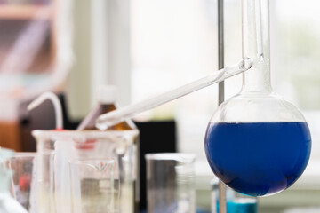Retort flask filled with a blue substance in a laboratory