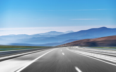 Mountain highway with blue sky and rocky mountains on a background