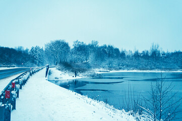 Snowy river bank in the evening in winter