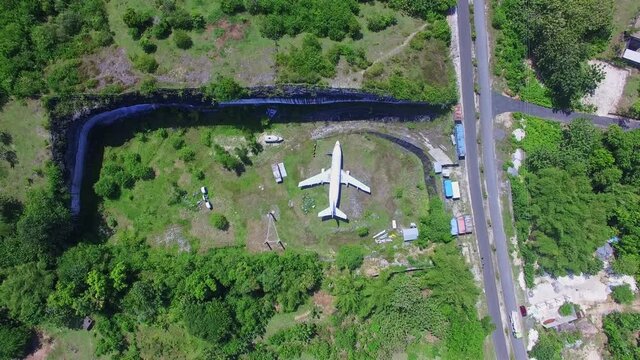Aerial view above a forlorn plane in Kuta Selatan and a quiet road, in Bali, Indonesia - tracking, birdseye, drone shot
