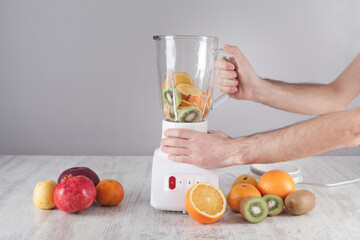 Man mixing fruits with blender.