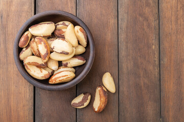 Brazil nuts on a plate over wooden table with copy space