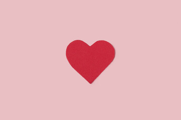 Minimalist picture of a red heart on a pink background