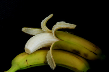 banane und geschälte banane vor schwarzen hintergrund