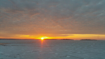 Sunrise in a cold winter morning with a icy lake in background