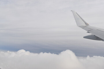 Fototapeta premium Beautiful white clouds floating high angle air, viewed from airplane window.